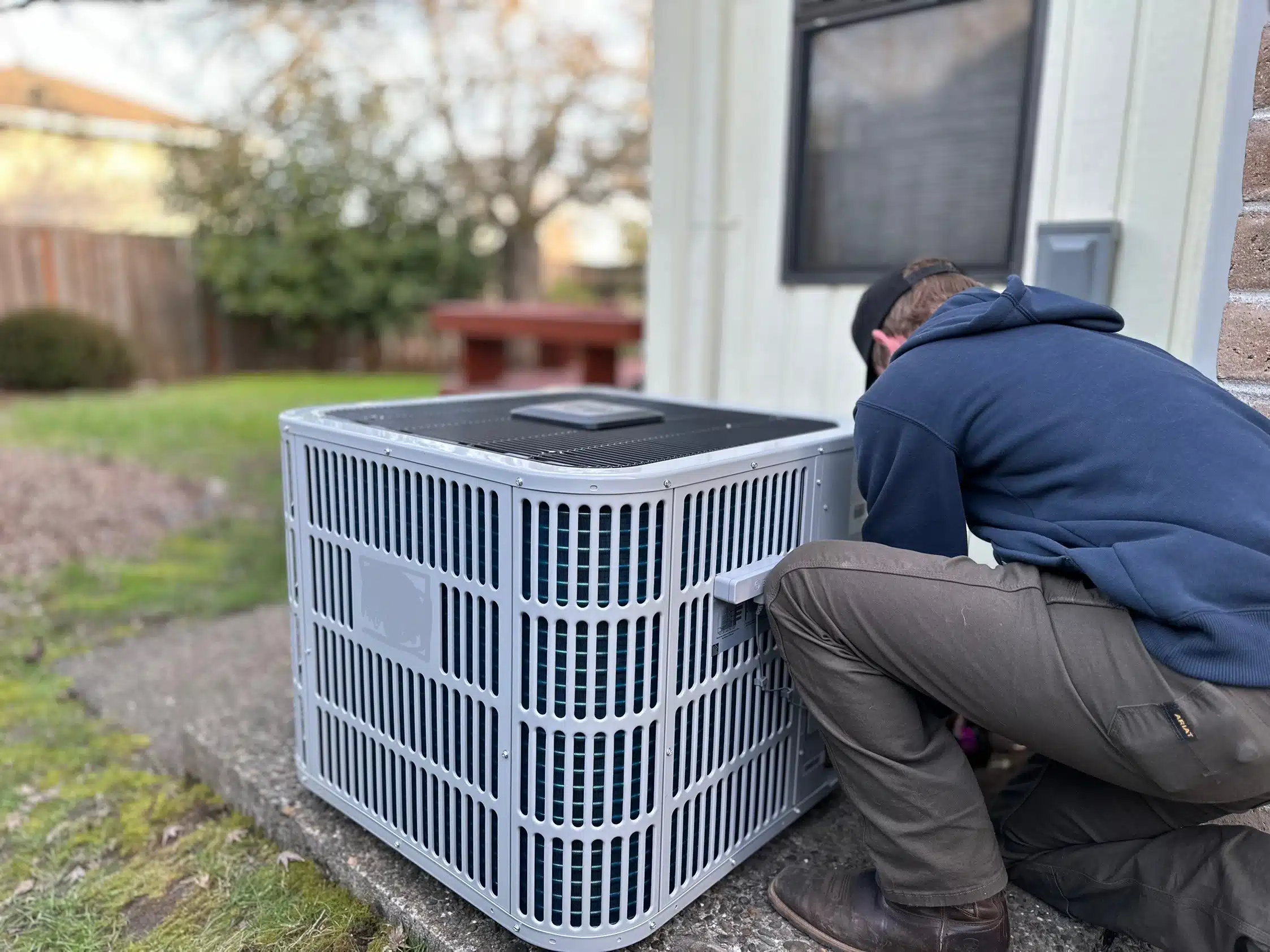 Oregon Climate Tech technician servicing an outdoor air conditioner.