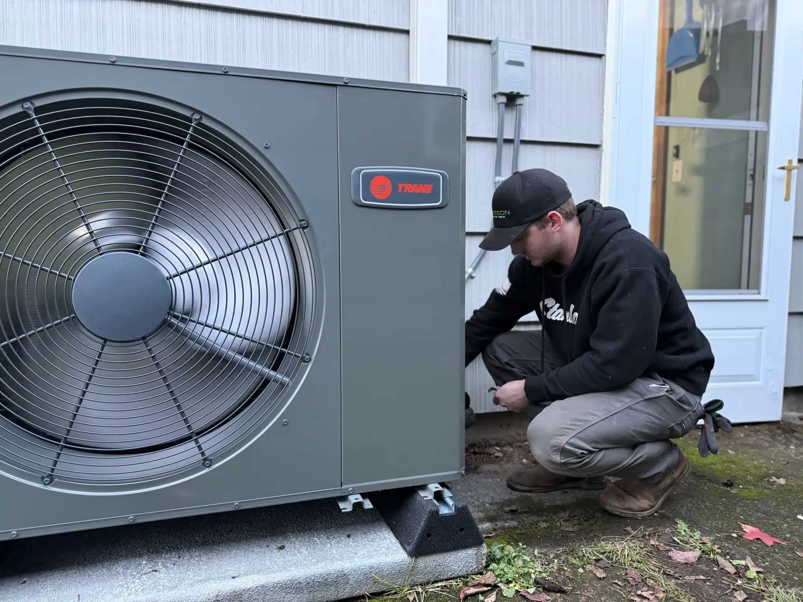 Oregon Climate Tech installer commissioning a Trane outdoor heat pump unit at a Portland home.
