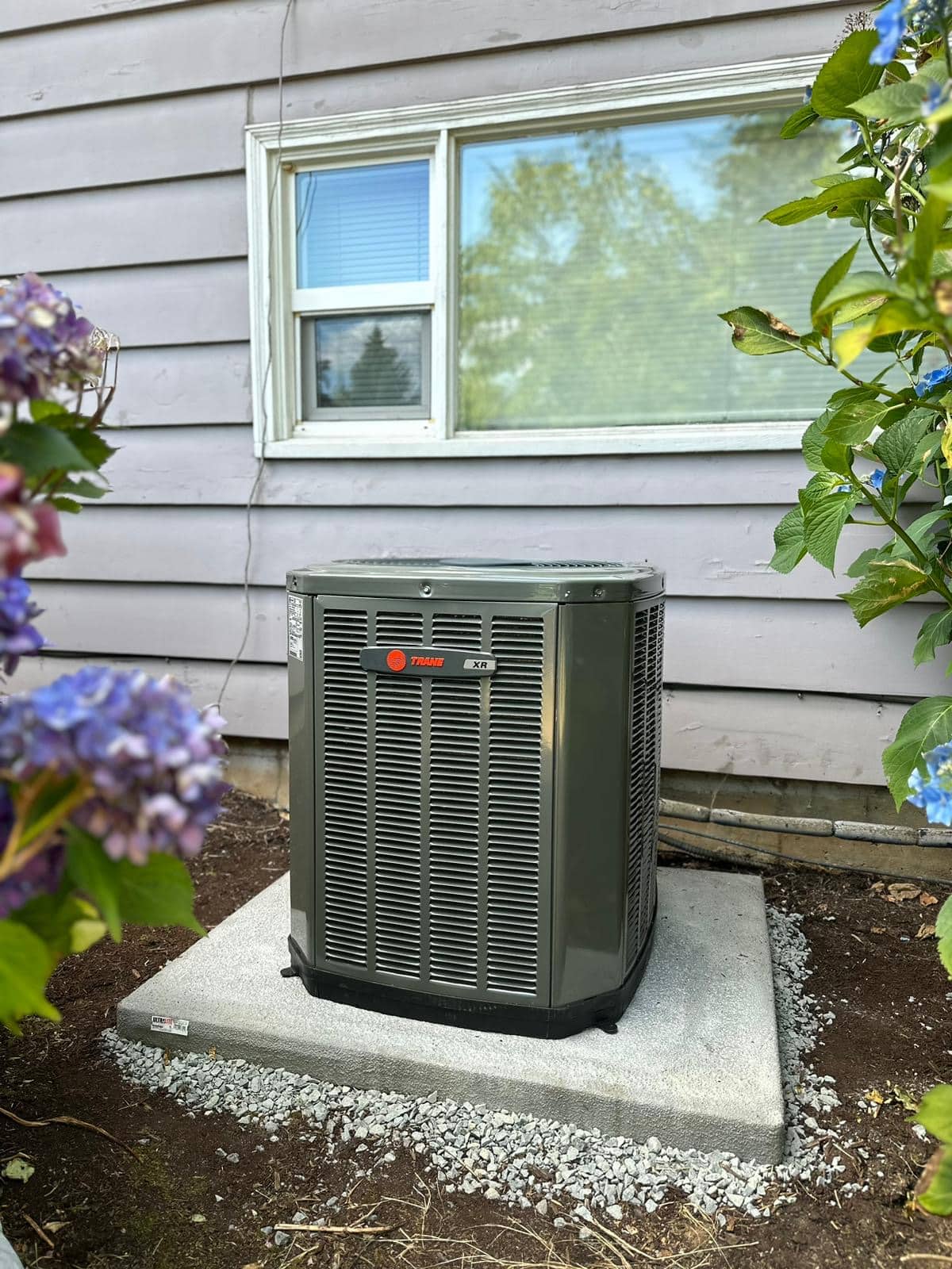 Outdoor AC condenser installed beside a Portland-area home.